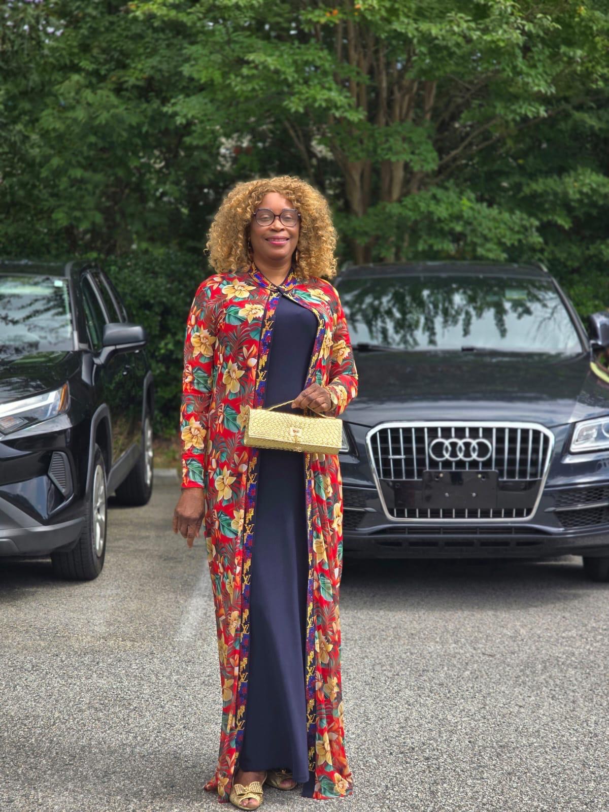 A Clara Loreva client styled in a custom printed duster over a navy gown, carrying a gold clutch