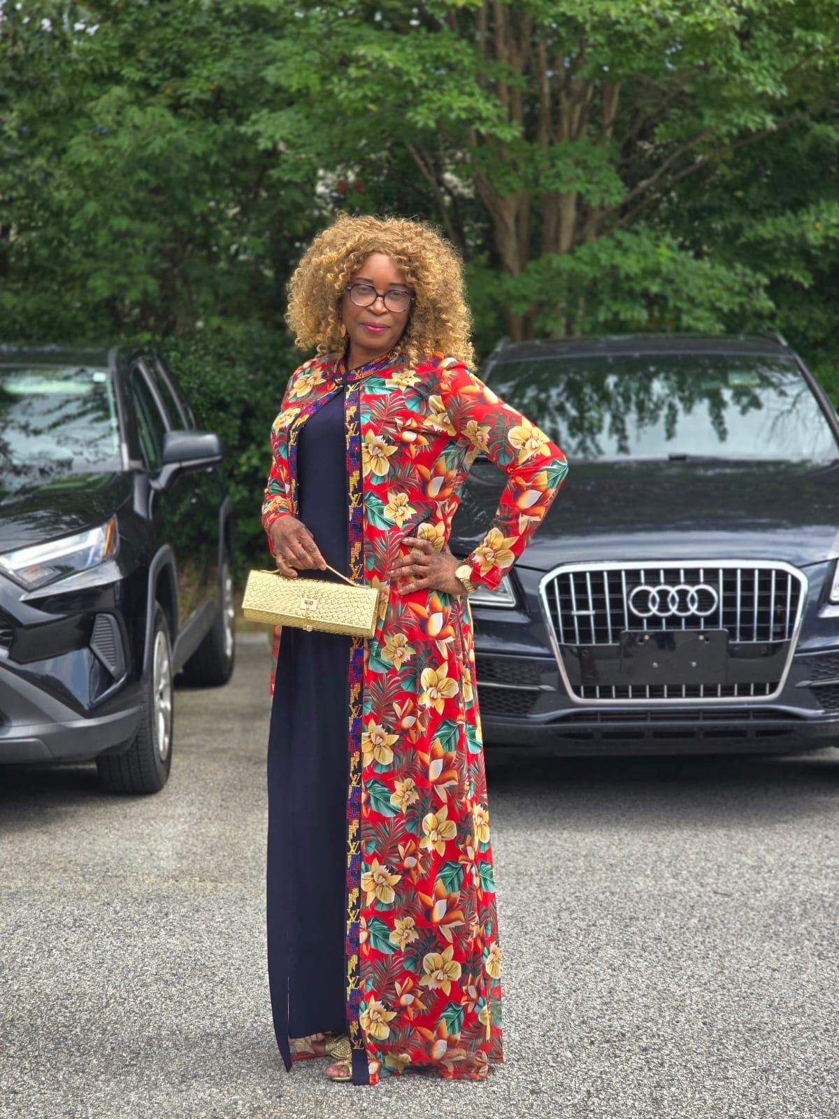 A Clara Loreva client styled in a custom printed duster over a navy gown, carrying a gold clutch